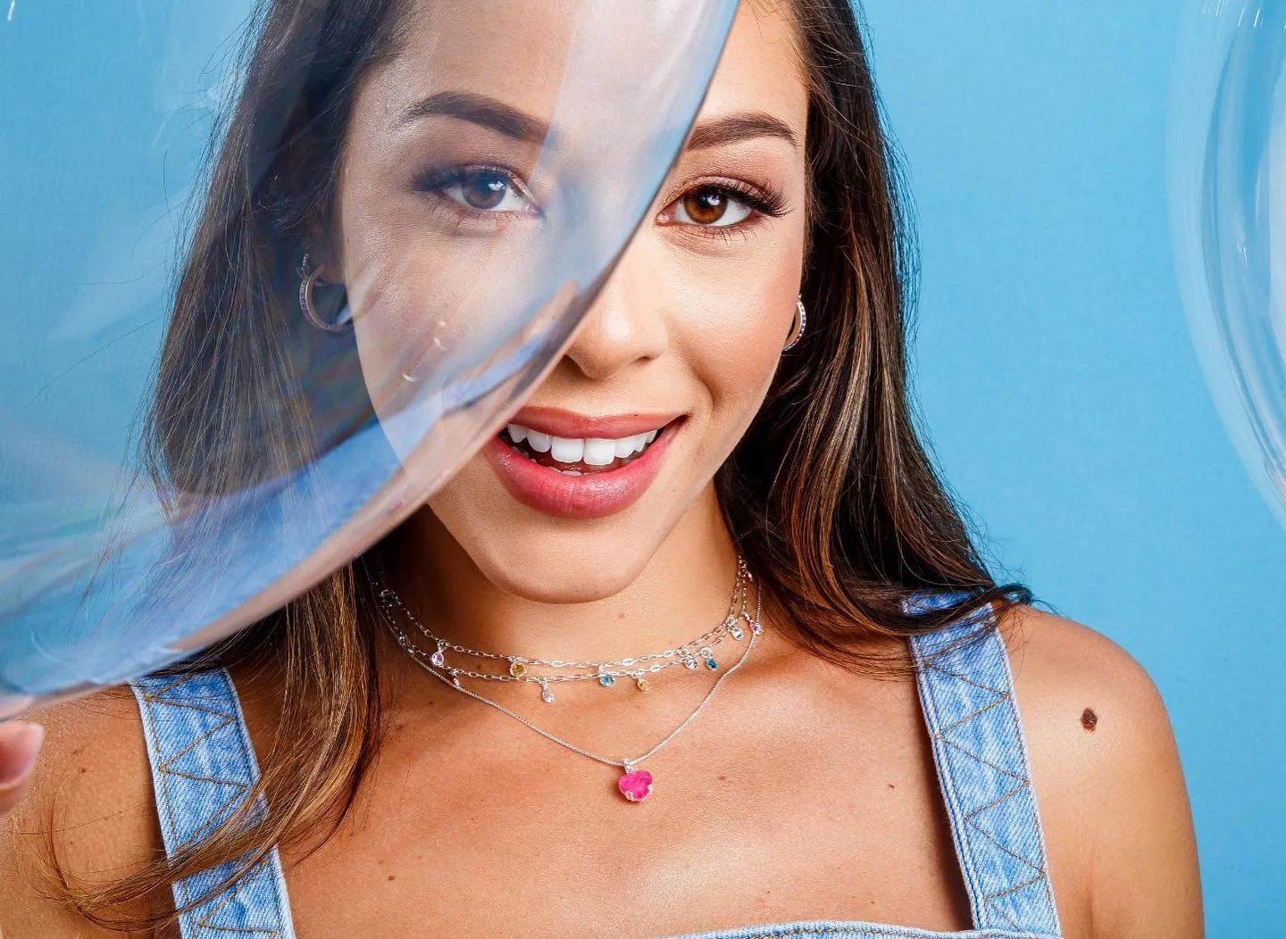 Retrato sorridente com joias e tecido translúcido azul