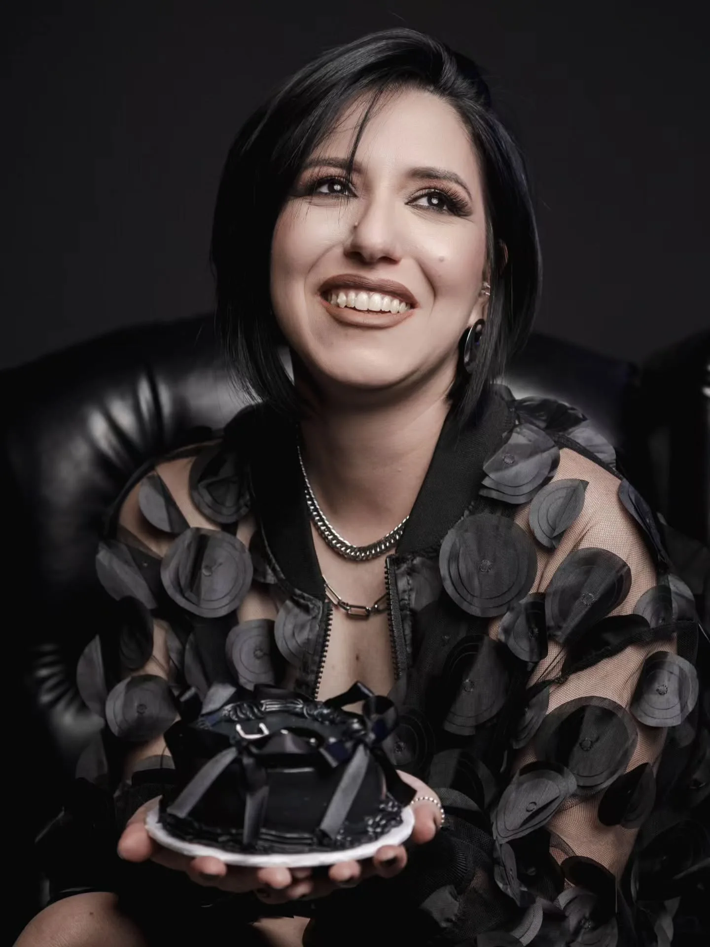 Retrato sorridente com roupa preta e pequeno bolo