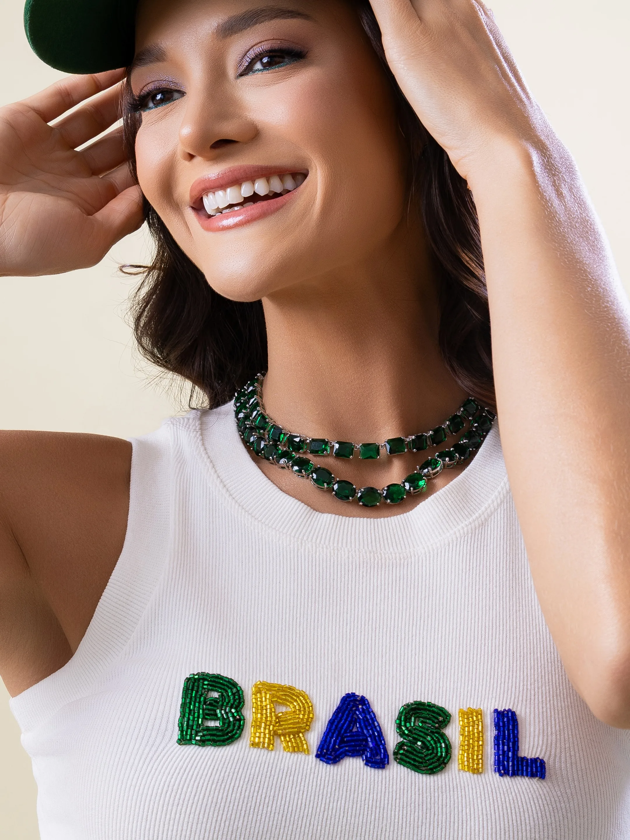 Detalhe de retrato com boné, colar verde e blusa Brasil
